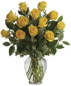 Dozen yellow roses in clear glass vase