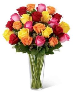 assorted coloruful roses in tall vase
