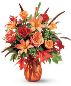orange and red flowers in orange glass vase