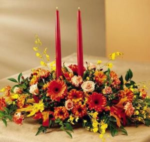 yellow and red flowers around two red candles