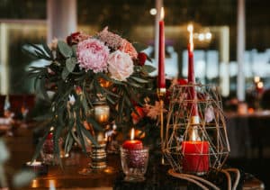 Beautiful, decorated table with flower decorations and red candles. Christmas evening or wedding party decoration.