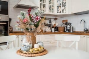 A spruce bouquet with red berries on a white kitchen table. Christmas decorations in the interior. The concept of preparing for the New year holiday.