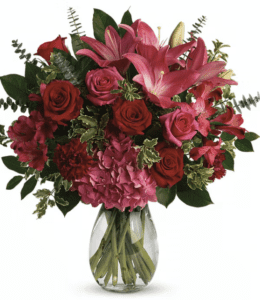 A luxurious bouquet that's sure to leave your special someone absolutely love struck! There's no denying the dramatic beauty of these radiant, red hot roses, hydrangea and lilies. This luxe arrangement includes pink hydrangea, hot pink roses, red roses, dark pink asiatic lilies, dark pink alstroemeria, maroon carnations, pitta negra, spiral eucalyptus, and lemon leaf. Delivered in a glass jordan vase. Approximately 17" W x 30"H